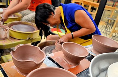 Person throwing a ceramic pot at Wheelhouse Studio