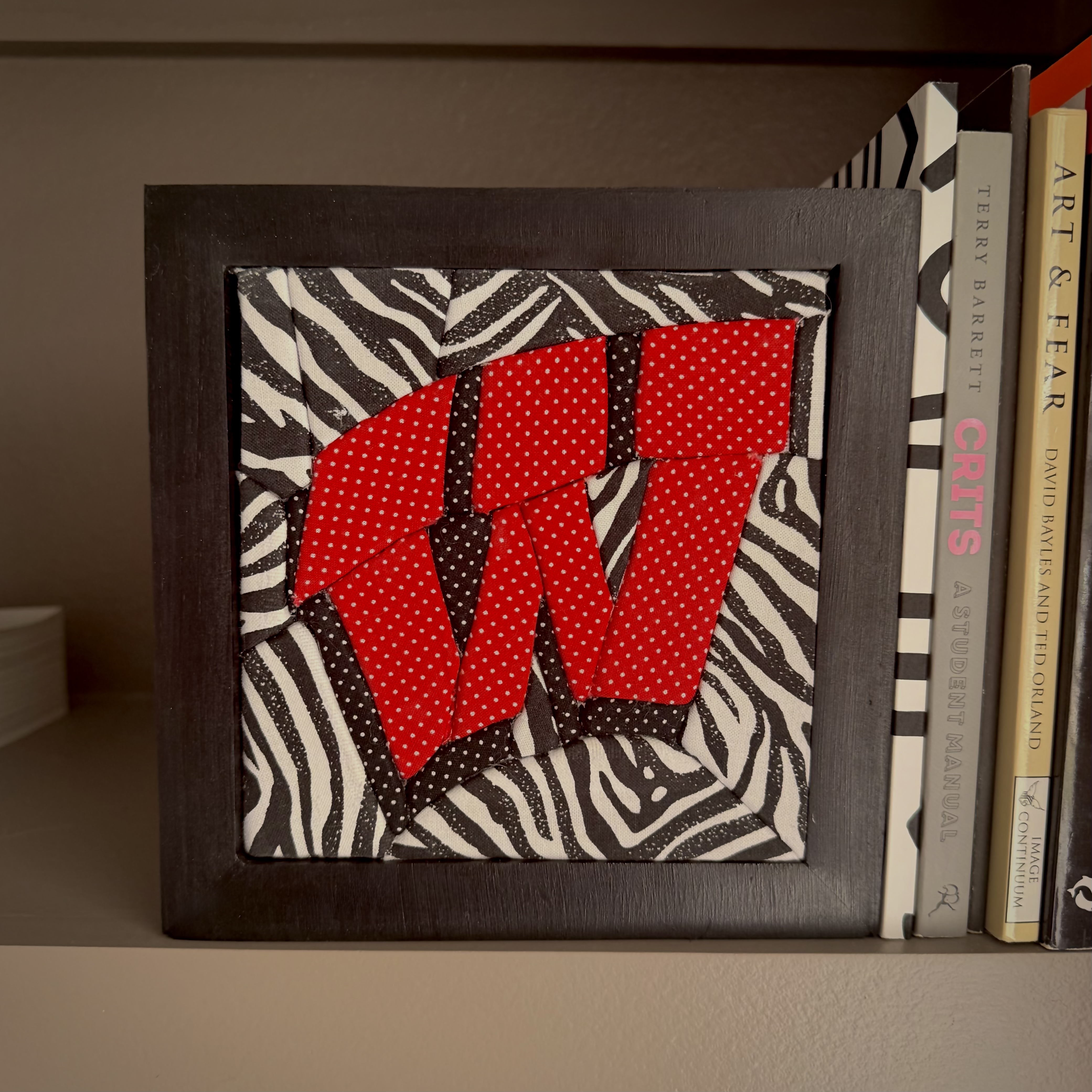 Photo of a picture frame with fabric spelling out a W.