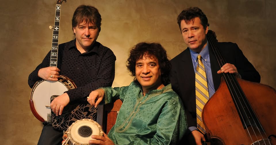 A trio holding their instruments in front of a brown backdrop.