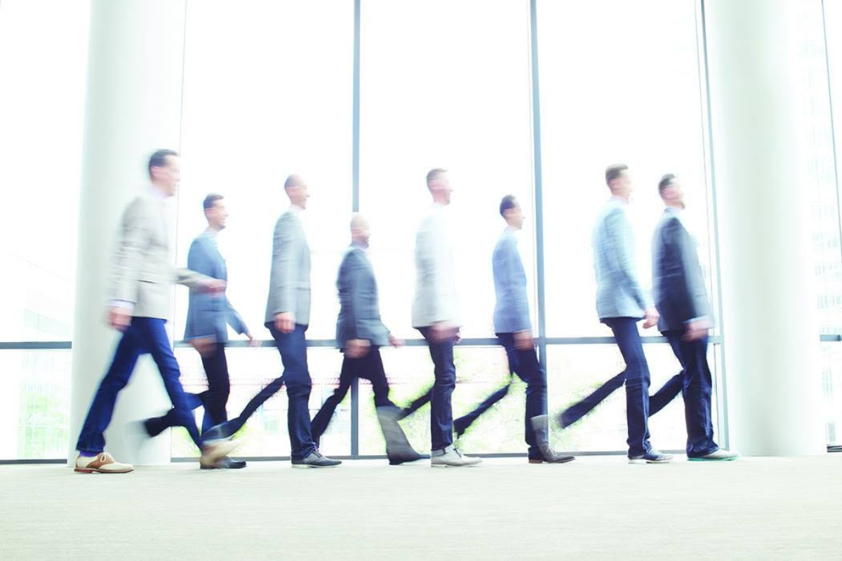 Blurred image of people in formal wear walking.