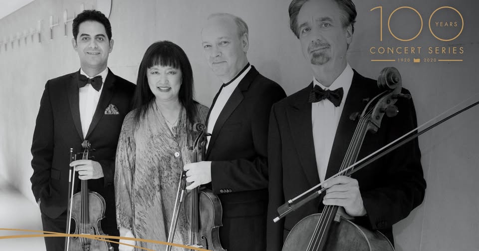 Black and white photo of a string quartet holding their instruments.