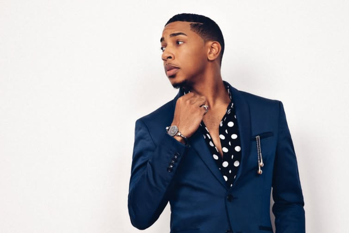 Christian Sands posing in front of a white backdrop.