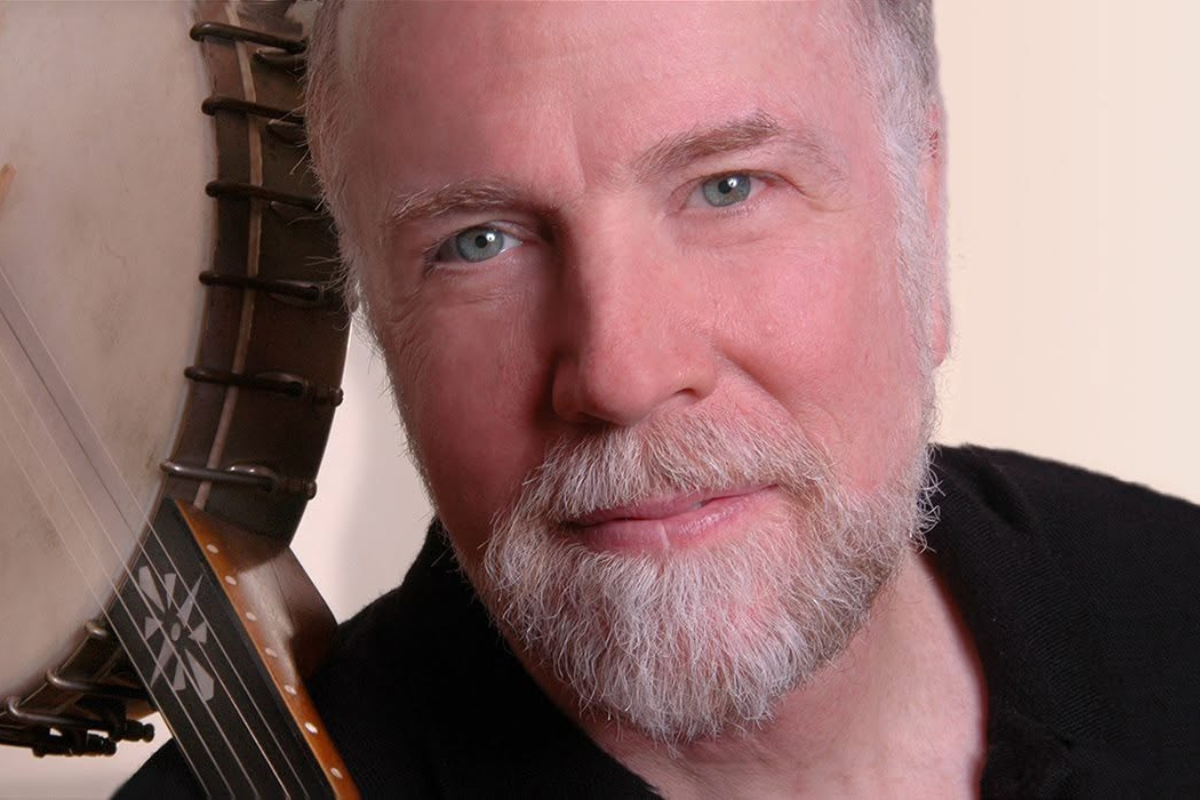 Close-up photo of a person with a banjo over their shoulder.