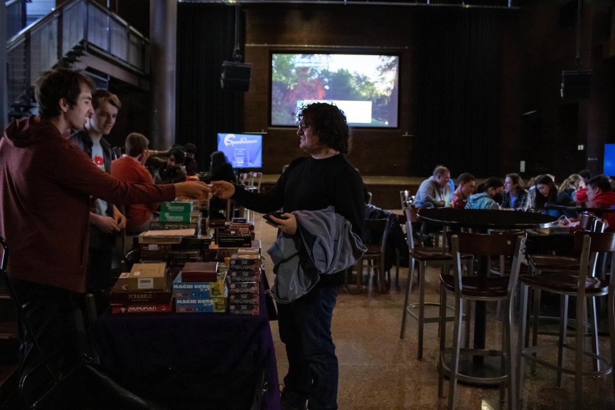 A guest is handed a board game at International Game Night