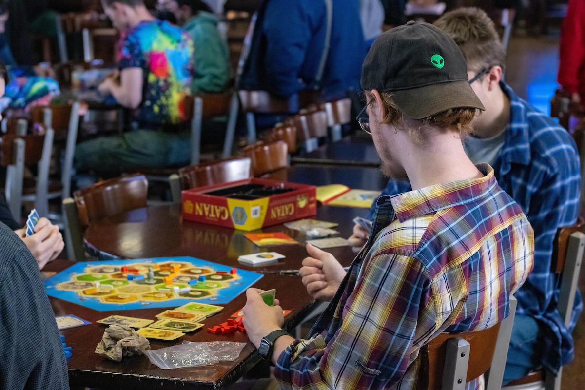 People play Catan at a table during International Game Night