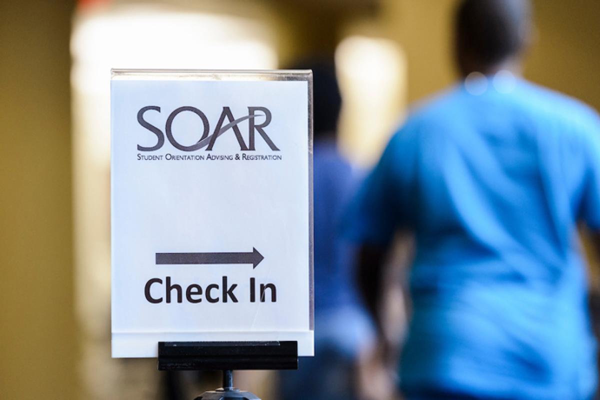 SOAR check-in sign pointing to a line of people