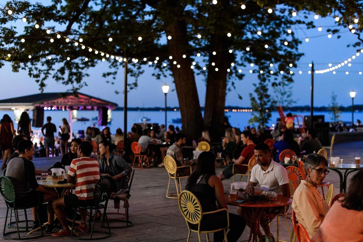People on the Terrace at night with string lights in the branches above