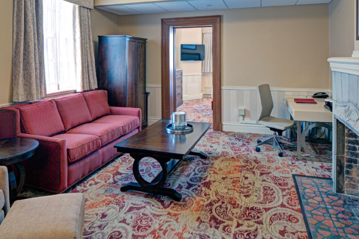 Memorial Union Club Suite living room area with sofa, desk, and fireplace