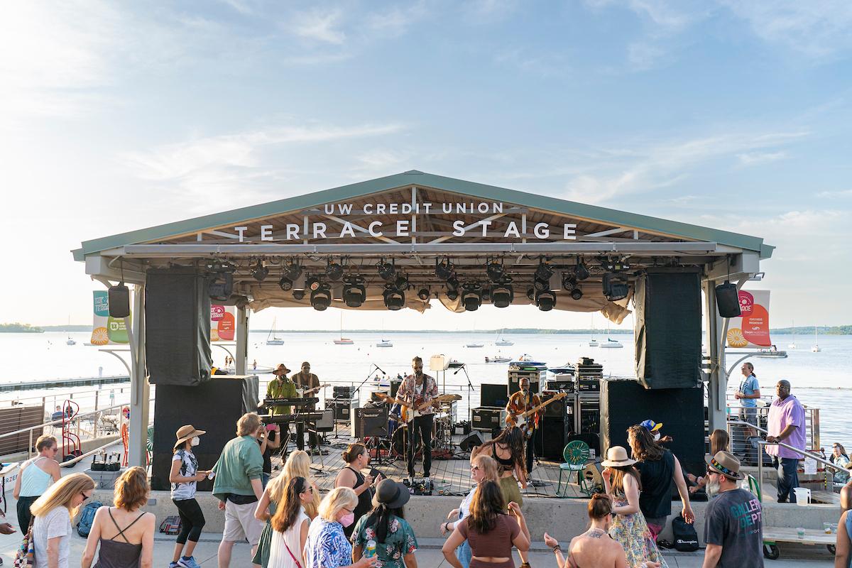 Individuals listening to a performance on the UW Credit Union Terrace Stage