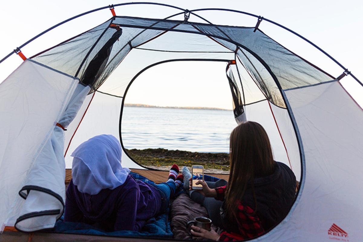 Two people in a tent by the lake