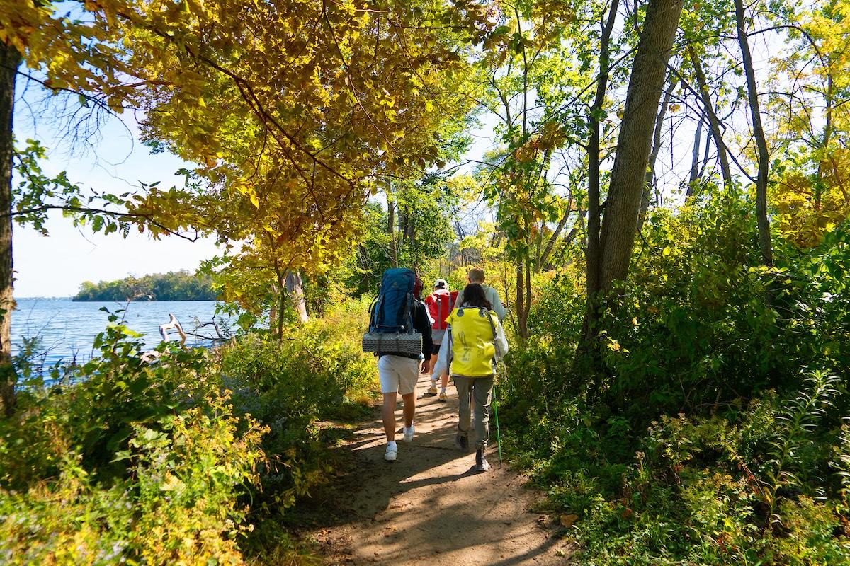 Two people hiking a trail next to the lake