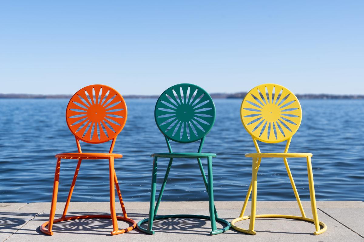 orange, green and yellow chairs sitting alongside shore of Lake Mendota