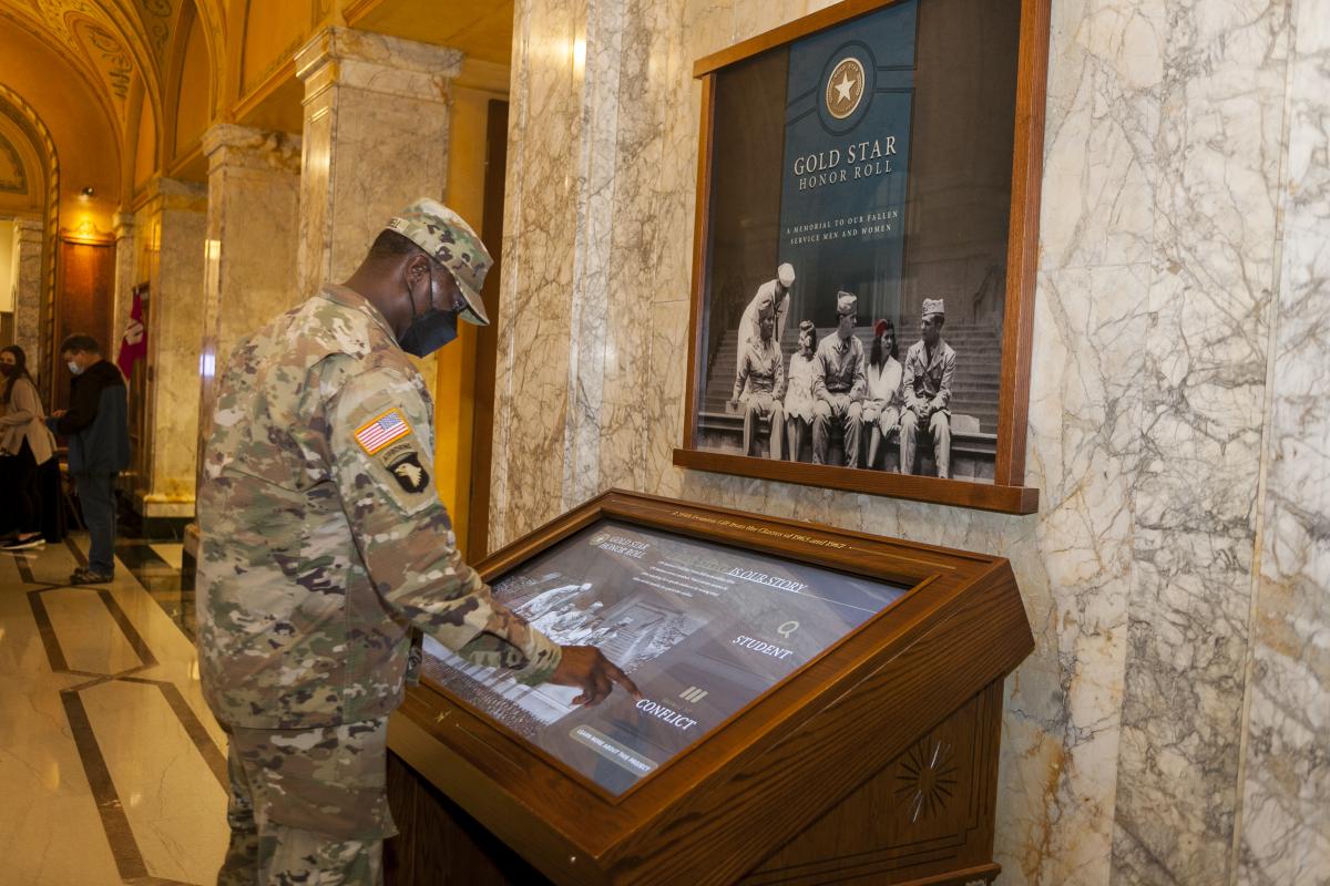 service member stands at electronic Gold Star Honor Roll in Memorial Hall, outside of Main Lounge at Memorial Union