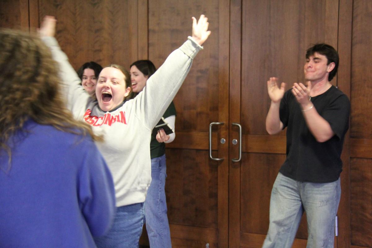 Students cheer on a girl during a WUD leadership training summit.