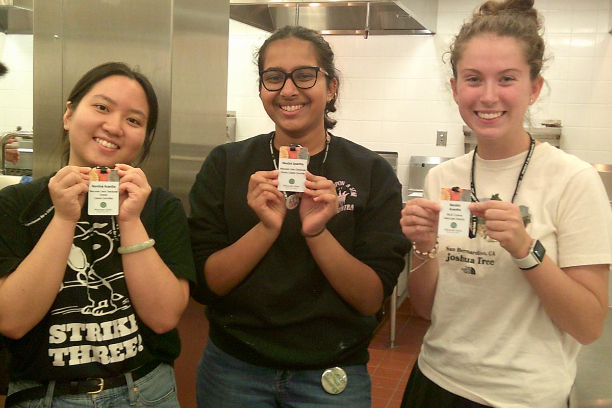 The WUD Cuisine leadership team poses with their badges at a cooking workshop.