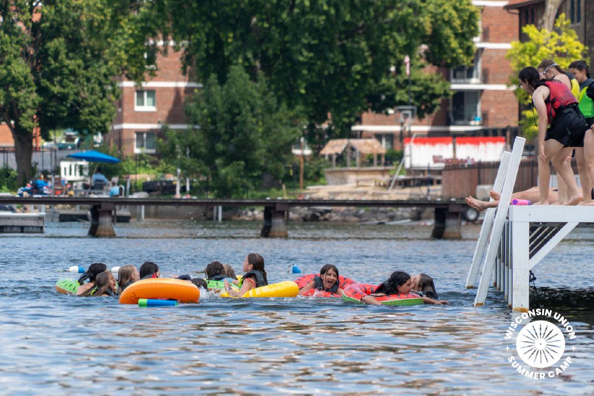 group of children swimming with intertubes.