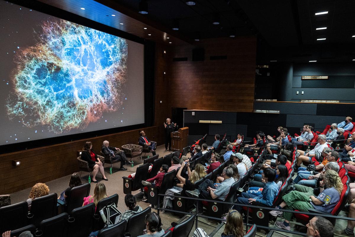 People in a movie theater space watching a presentation on space.