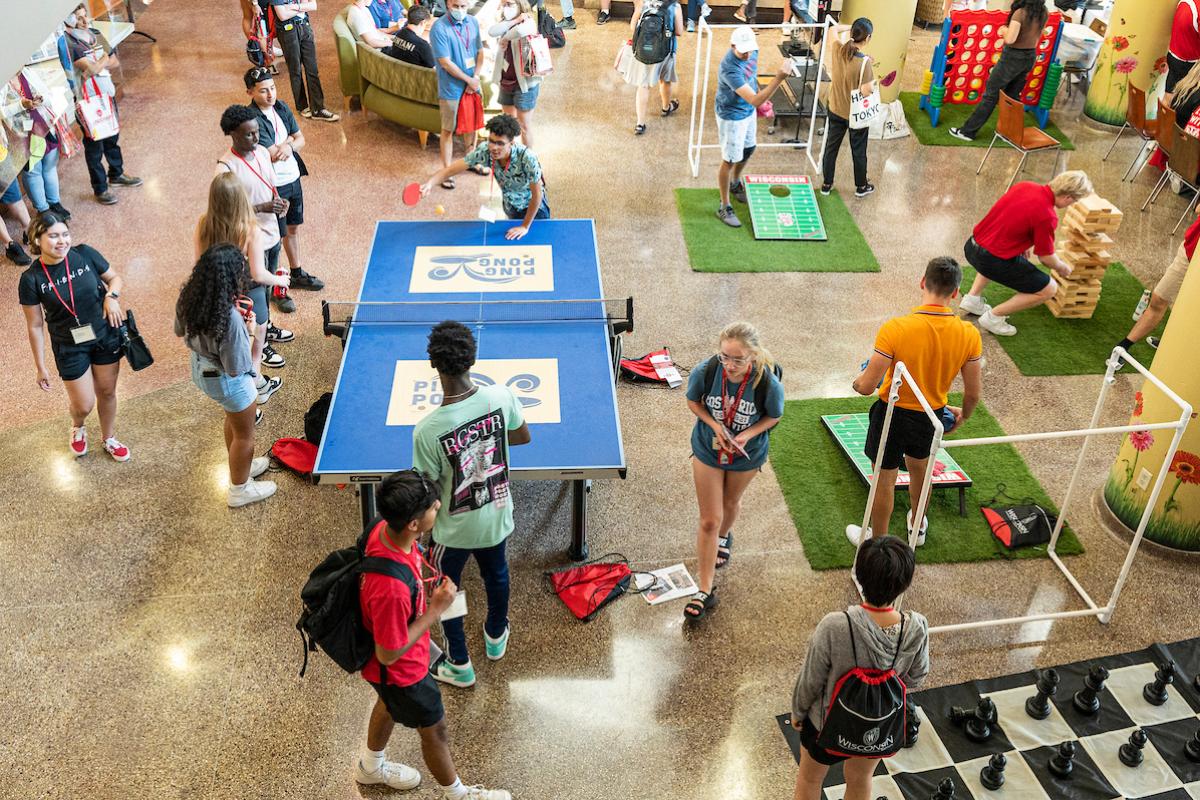 Students playing ping pong, bags, and other games in the Sun Garden at Union South.