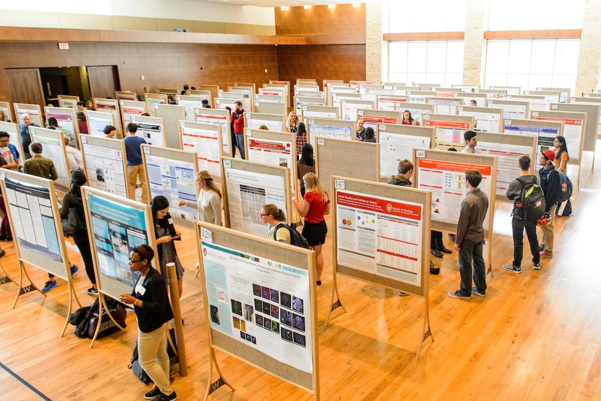 Undergraduate symposium, with many students standing by their research posters.