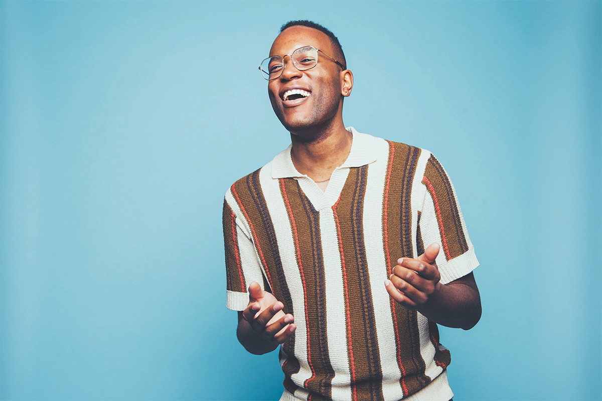 Michael Mayo standing in front of a blue background.