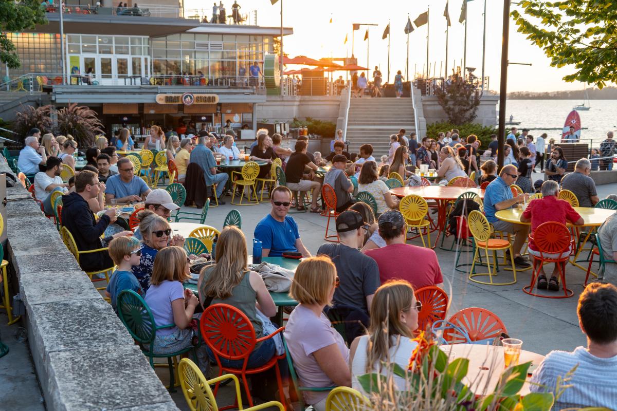An audience of seated patrons enjoys live music on the Terrace at sunset.