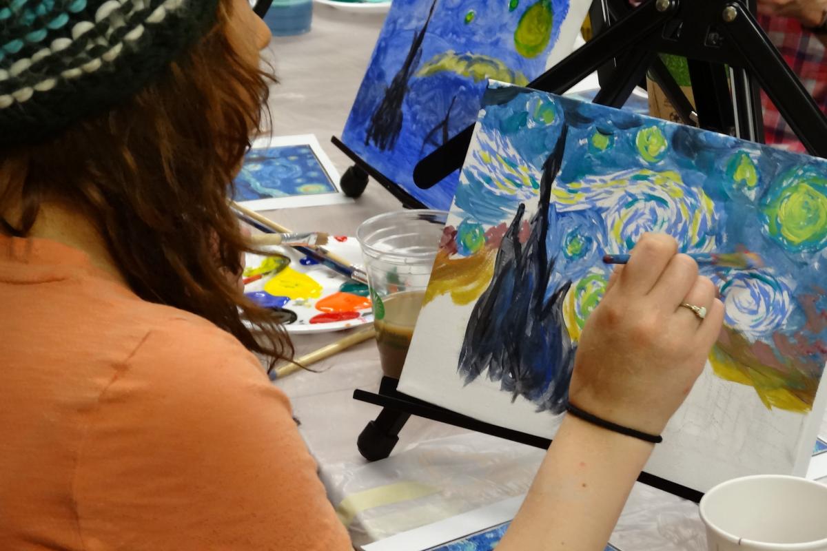 Photo of someone painting the famous Starry Night piece.