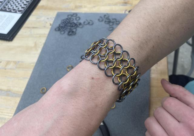 Artist wearing a chainmaille bracelet they've made at Wheelhouse Studios
