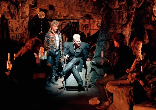 Image from film The Lost Boys, men sit in dimly lit room.