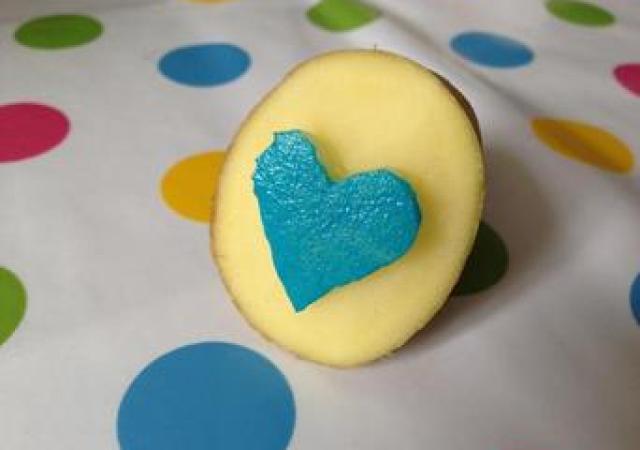 Potato carved into a blue heart stamp
