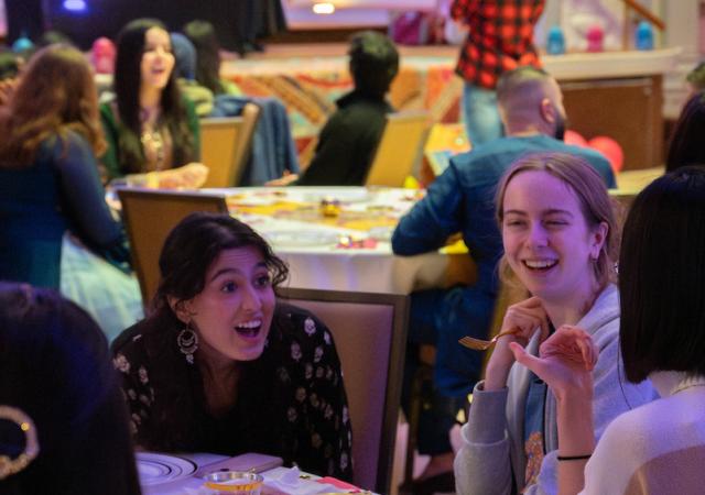 three people smiling with food in front of them and colorful background