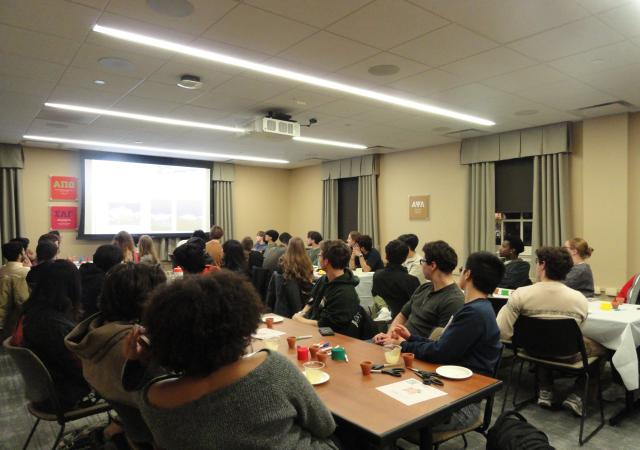 students watching presentation on screen in a cream colored room
