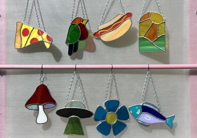 Selection of suncatchers in various shapes, including a pizza, a hot dog and a mushroom.