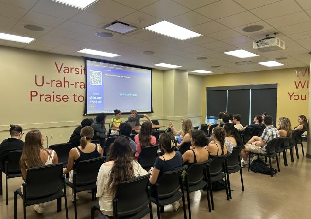 students watching a presentation lead by wud volunteer action presdient