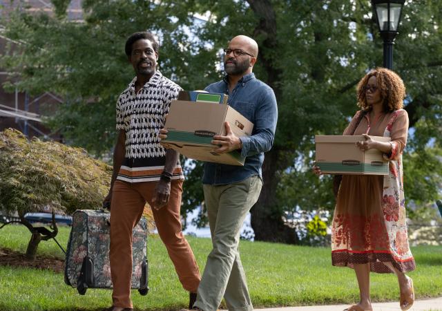 Still from film American Fiction, three people carrying moving supplies walk down the sidewalk.