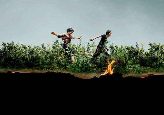 Poster from film Monster (2023), two boys run through a field.