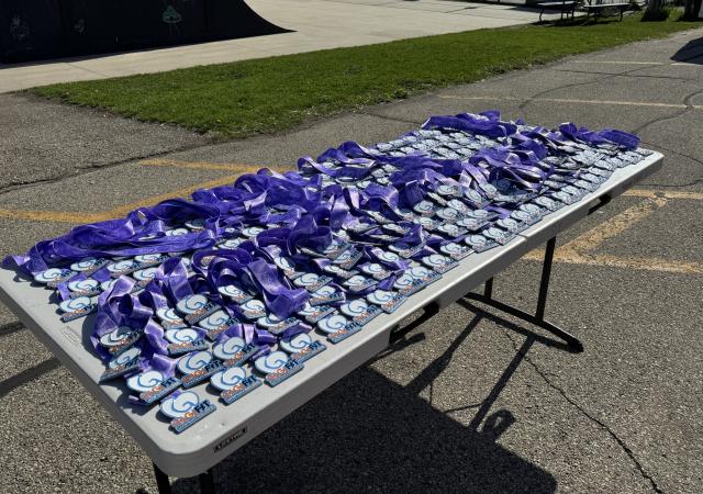 table filled with medals for completing dash for down syndrome race