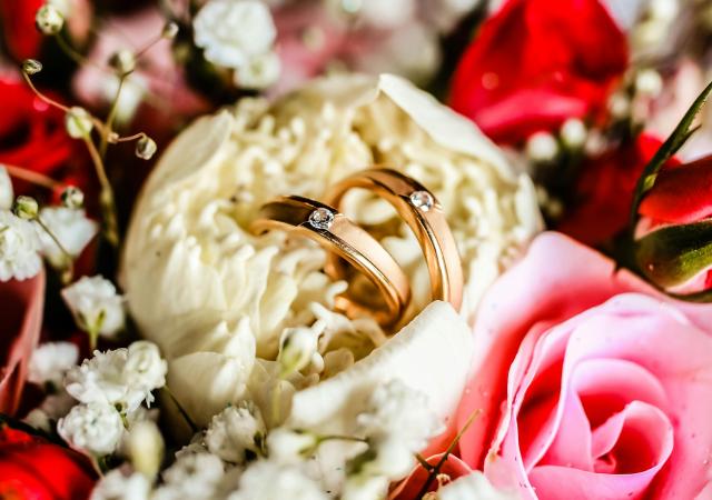 Wedding bands staged in a bouquet of flowers.