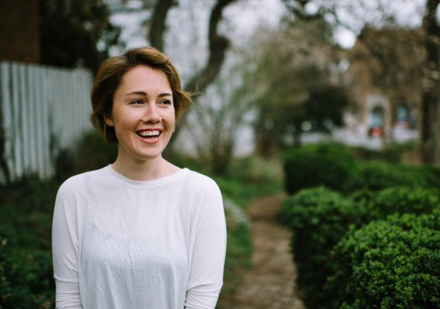 Photo of Caroline Shaw with a green background.