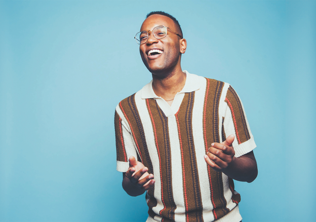 Michael Mayo standing in front of a blue background.