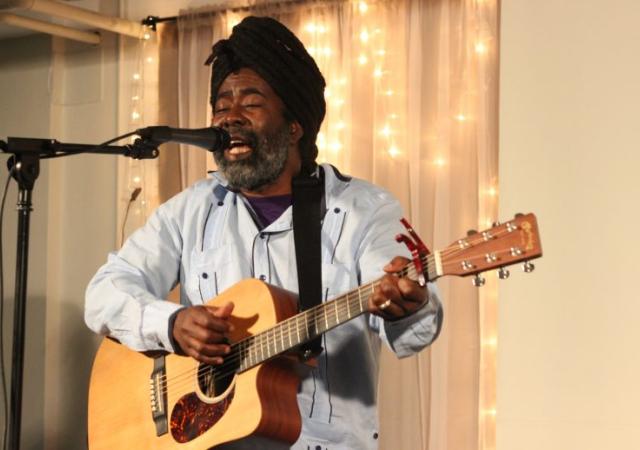 Mona Augustin performing with an acoustic guitar.