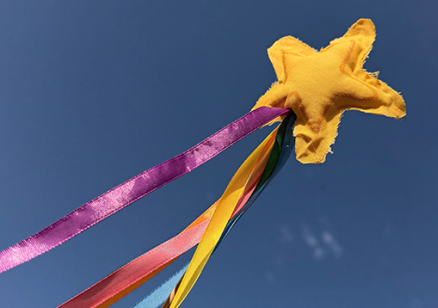 Image of a Pride Magic Wand with a star at the top with colorful ribbon.