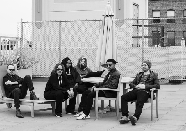 Black and white photo of Terri Lyne Carrington + Social Science sitting outside.