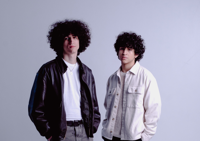Photo of Zohar and Adam standing in front of a light gray backdrop.