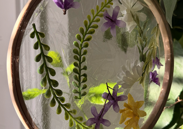 A photo of pressed flowers in a sun catcher.