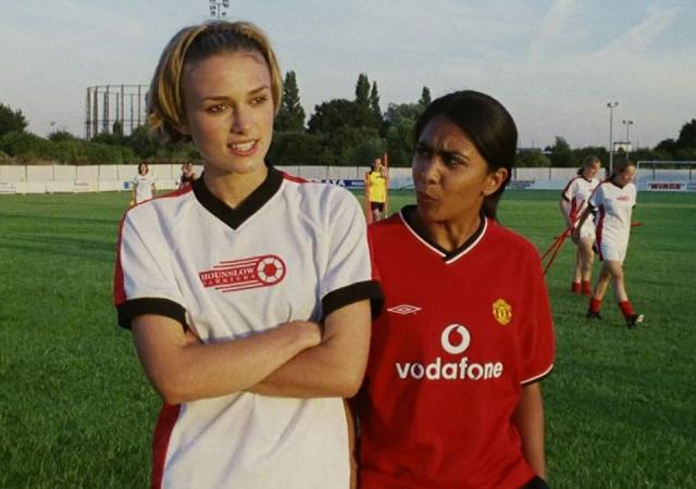 two female socker players, one with a white jersey (left) and one with a red jersey (right)