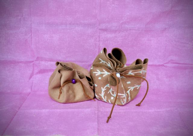 Photo of draw string brown bags against a pink back drop.