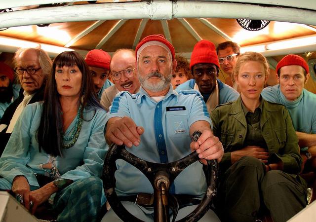 ten adults sitting in a row inside a submarine