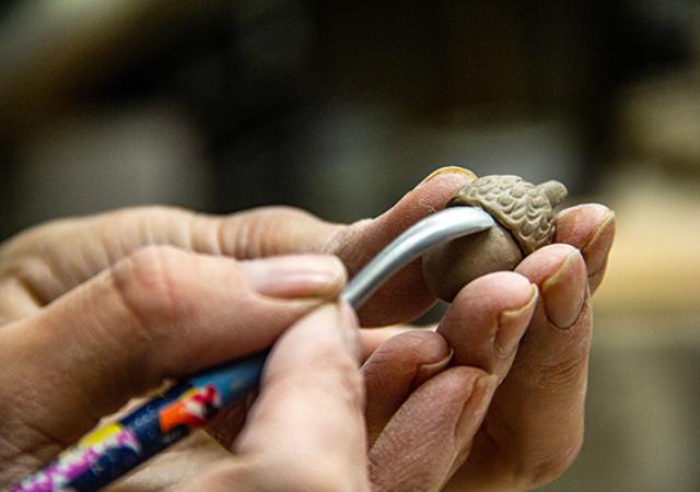 Photo of a person handbuilding out of ceramics.