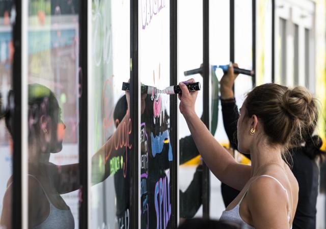Student decorates one of the exterior glass window panels of the Memorial Union