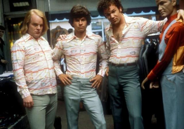 Three men wearing striped shirts posing next to a mannequin.